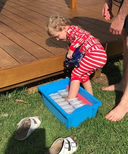 Toddler washing feet with a foot washer